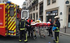 Firefighters carry an injured man on a stretcher in front of the offices of the French satirical newspaper Charlie Hebdo in Paris on January 7, 2015. (Xinhua/AFP Photo)