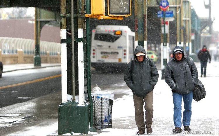 Pedestrians walk in snow in a street in New York City, the United States, Jan. 26, 2015. 