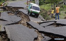 People walk on a damaged road in Kathmandu, capital of Nepal, on April 25, 2015. 