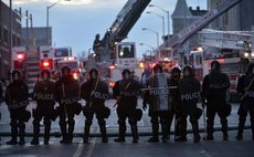 Policemen guard near a CVS pharmacy store which was set ablaze in Baltimore, Maryland, the United States, April 27, 2015. (Xinhua/Yin Bogu)