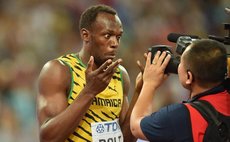 Bolt has fun with a cameraman after winning the 100 metres race