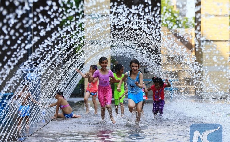  Children cool off in a wading pool in Toronto, Canada, June 20, 2016. Toronto issued an extreme heat alert on Monday, and the forecasted high was 34 degrees Celsius. (Xinhua/Zou Zheng)