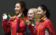 Virginia Thrasher (C) of the United States, Du Li (L) and Yi Siling of China attend the awarding ceremony of the Women's 10m Air Rifle of shooting of the 2016 Rio Olympic Games 