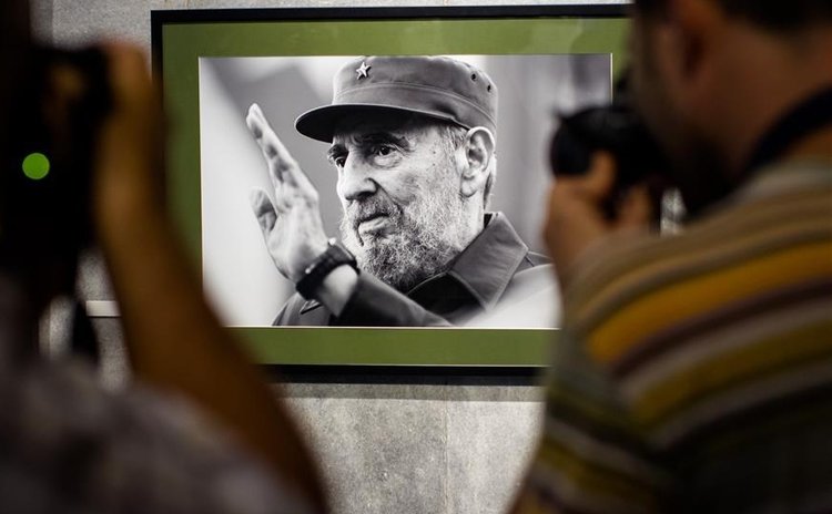 File photo taken on Aug. 12, 2014 shows people taking photos of a picture of Fidel Castro prior to his 88th birthday in Havana, Cuba