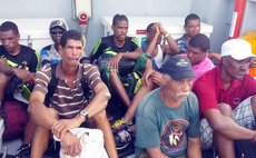 Pensive faces of Petite Savanne residents on a boat as they leave their village