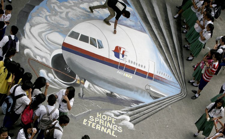 MAKATI CITY, March 17, 2014 (Xinhua) -- Students watch a three-dimensional graffiti as a way of sympathizing to the missing Malaysian Airlines flight MH370 at a school in Makati City, the Philippines,