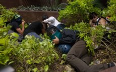 CARACAS, April 5, 2014 (Xinhua) -- Demonstrators take cover during a clash with Bolivarian National Guard in an anti-government protest, in Caracas, Venezuela, on April 4, 2014. 