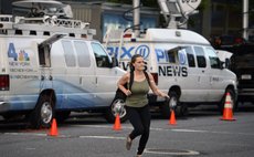 NEW YORK, Aug. 5, 2014 (Xinhua) -- A woman walks past brocasting vans in front of Mount Sinai Hospital in New York, the United States, Aug. 4, 2014