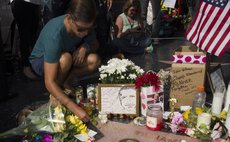 LOS ANGELES, Aug. 12, 2014 (Xinhua) -- A man lays flowers at Robin Williams' star on the Hollywood Walk of Fame in Hollywood, California, the United States, Aug. 12, 2014. 