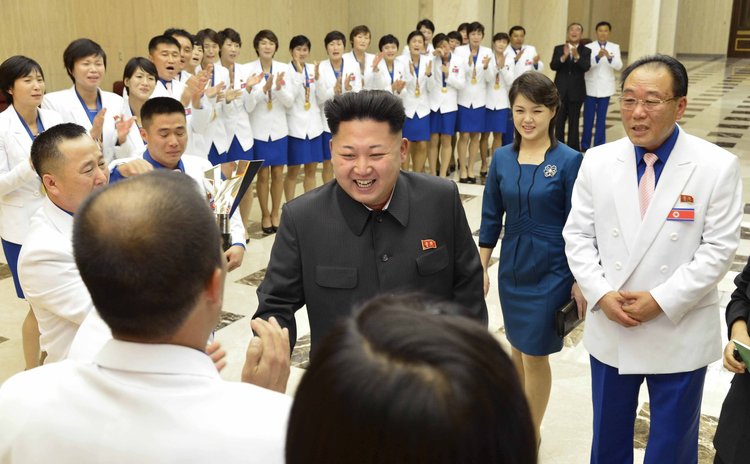 PYONGYANG, Oct. 19, 2014 (Xinhua) -- Korean Central News Agency (KCNA) photo shows Kim Jong Un, and wife Ri Sol-Ju (2nd R) meeting with gold medalists of the 17th Asian Games 