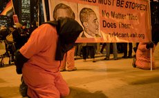 CHICAGO, Dec. 11 (Xinhua) -- Activists are dressed up as prisoners to protest American torture in Chicago on Dec.10, 2014