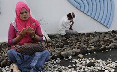 BANDA ACEH, Dec. 26, 2014 (Xinhua) -- Indonesian Muslims pray during the commemoration of 10th anniversary of the devastating tsunami at Sirion mass grave in Banda Aceh, Indonesia, Dec. 26, 2014