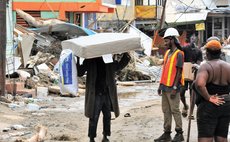 On Hillsborough Street, Roseau, a man carries a mattress and a pillow along with it