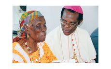 Archbishop Felix speaks with a centenarian in Soufriere in 2011