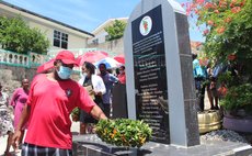 Resident of Pointe Michel place wreath at monument