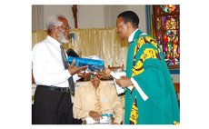 Bro Mo, left, receives gift from Fr. John Lewis