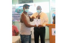 Trade Minister Ian Douglas hands certificate to course participant