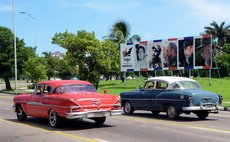 Image taken on Aug. 11, 2016 shows vehicles passing a billboard featuring retrospective photos of Fidel Castro, in Havana, capital of Cuba