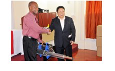 Chinese Ambassador Li Jiangning, right , hands fooging machine to Parliamentary Secretary Stevenson