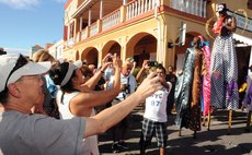 Cruise visitors take pictures of carnival band at the Roseau Cruise Ship berth