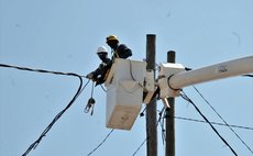 High above the streets in Roseau DOMLEC workers repair lines damaged by Hurricane Maria