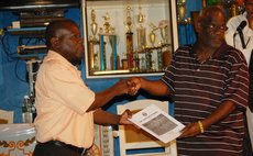 Don Leogal presents a book at the launch ceremony