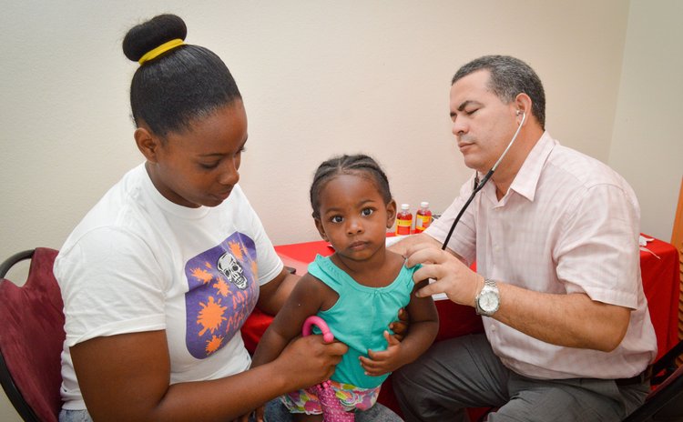A health professional checks a young patient