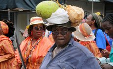 Castle Bruce woman plays mas with a coconut and a breadfruit