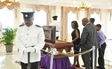 Frderick Baron, right, takes a look at his father's body at the State House this morning