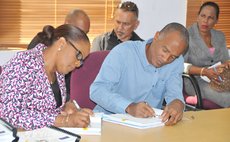 Roberts, left, and contractor sign documents