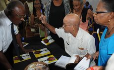 Fr Jolly, centre, signs books at launch at the Fort Young Hotel Friday 9 September 2016