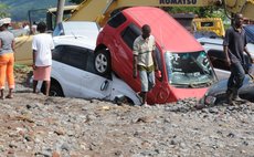 Men walk near buried cars at Massacre