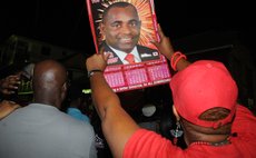  Asupporter holds up a poster of Skerrit at a party rally