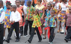 A young boy marches on Independence Street during the National Dress Parade