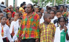  A teacher takes care of his pupils in the National Dress Parade
