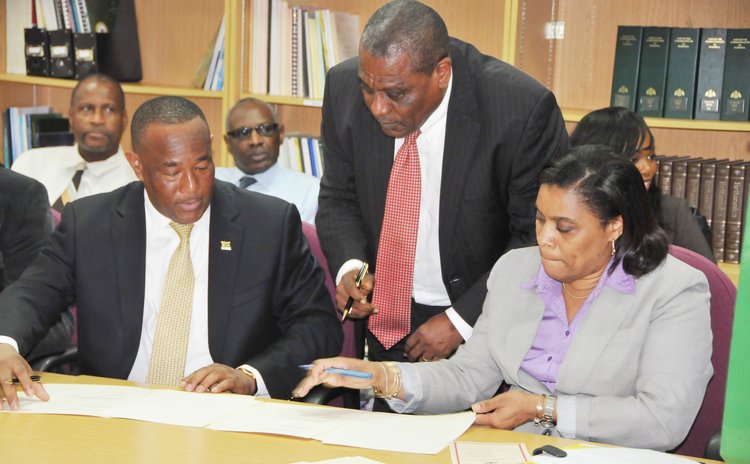 AIDB chairman Martin Charles, left, AIDB Manager Corbette and Finacial Secretary Rosmond Edwards at the signing ceremony