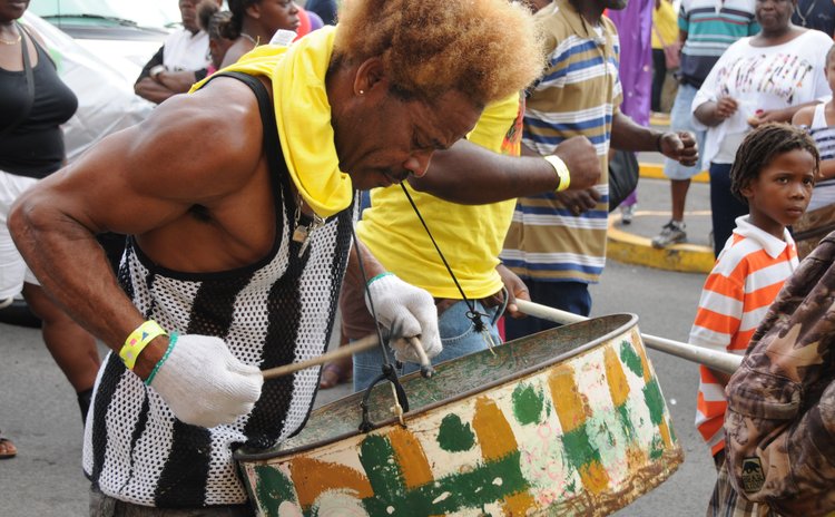 Man plays rust steel pan at the opening of Carnival