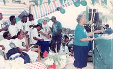Southwell, centre wearing green shirt, with Charles Savarin and Dame Eugenia Charles (at podium)
