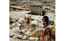 Woman and child sits on rocks after massive earthquake- Haiti