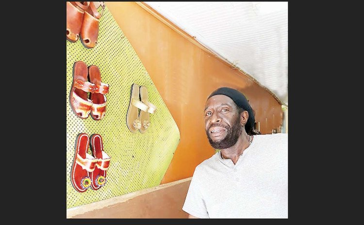 Henry Hilaire and some of his shoes on dispaly