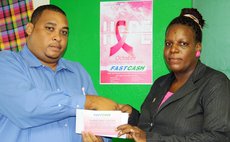 President of the Dominica Cancer Society accepts donation from Fast Cash official