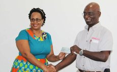 John Lewis hands over cheque to representative of the Dominica Infirmary