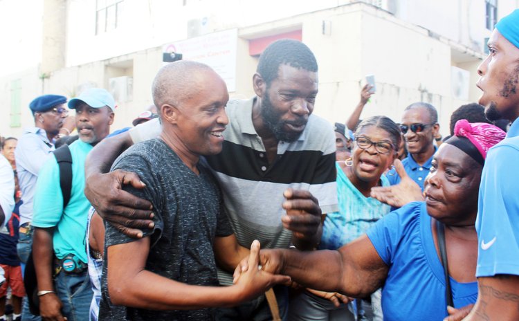 Supporters hug Spags John after he was released on bail