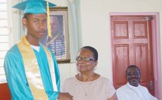 Valedictorian Jno Baptiste receives award from Mrs. Leevy