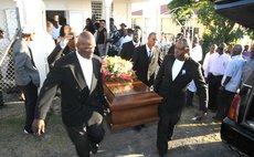 Pallbearers carry the body of Vernon Vidal to his resting place