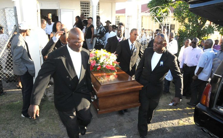 Pallbearers carry the body of Vernon Vidal to his resting place