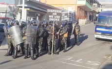 Police prepare to dispense tear gas at crowd new Gas Station