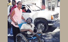 Founder of DADP Reggie Rolle in wheelchair being pushed by wife Nathalie 