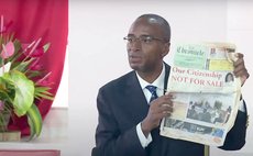 Senator Sean Douglas shows an old newspaper in parliament