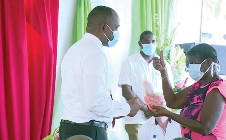 Prime Minister Skerrit hands over keys to a house to Grand Bay woman